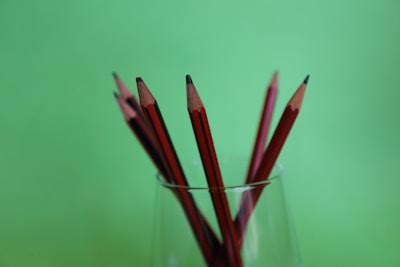 A set of sharpened pencils arranged in a cup on a study table.