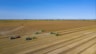 green and black tractor on brown field under blue sky during daytime