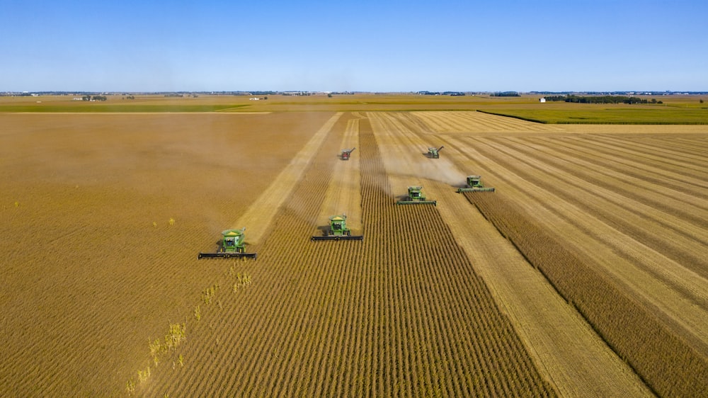 green truck on brown field under blue sky during daytime