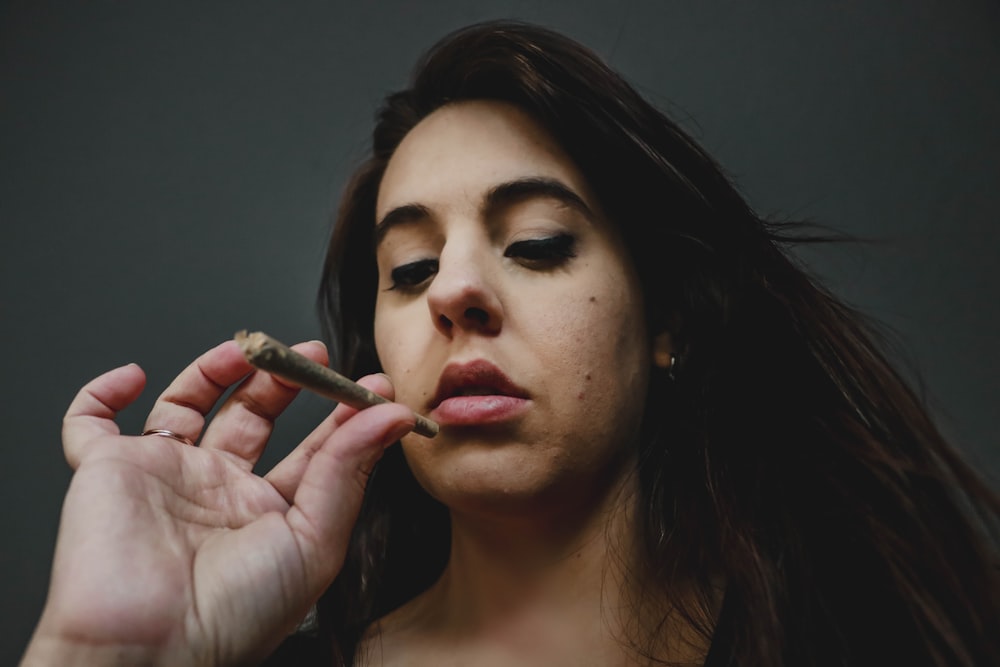 woman with red lipstick holding cigarette stick