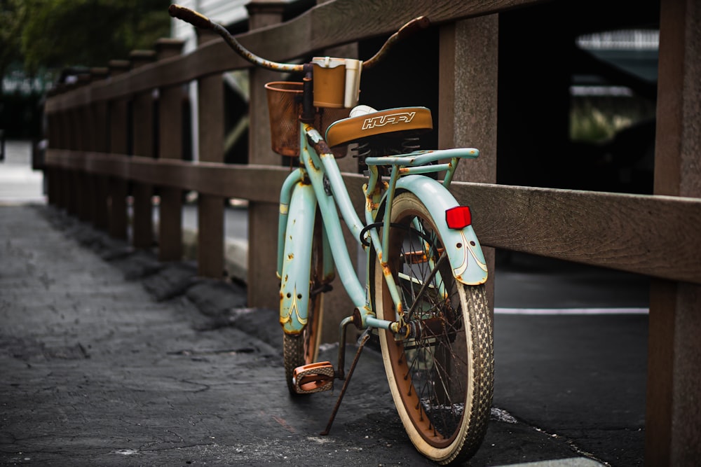 green city bike parked on sidewalk during daytime