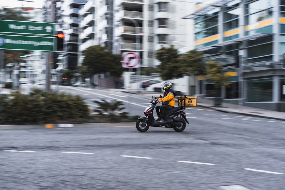 man in yellow jacket riding motorcycle on road during daytime