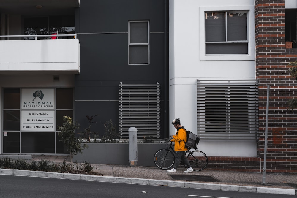 man in yellow shirt riding bicycle on road during daytime