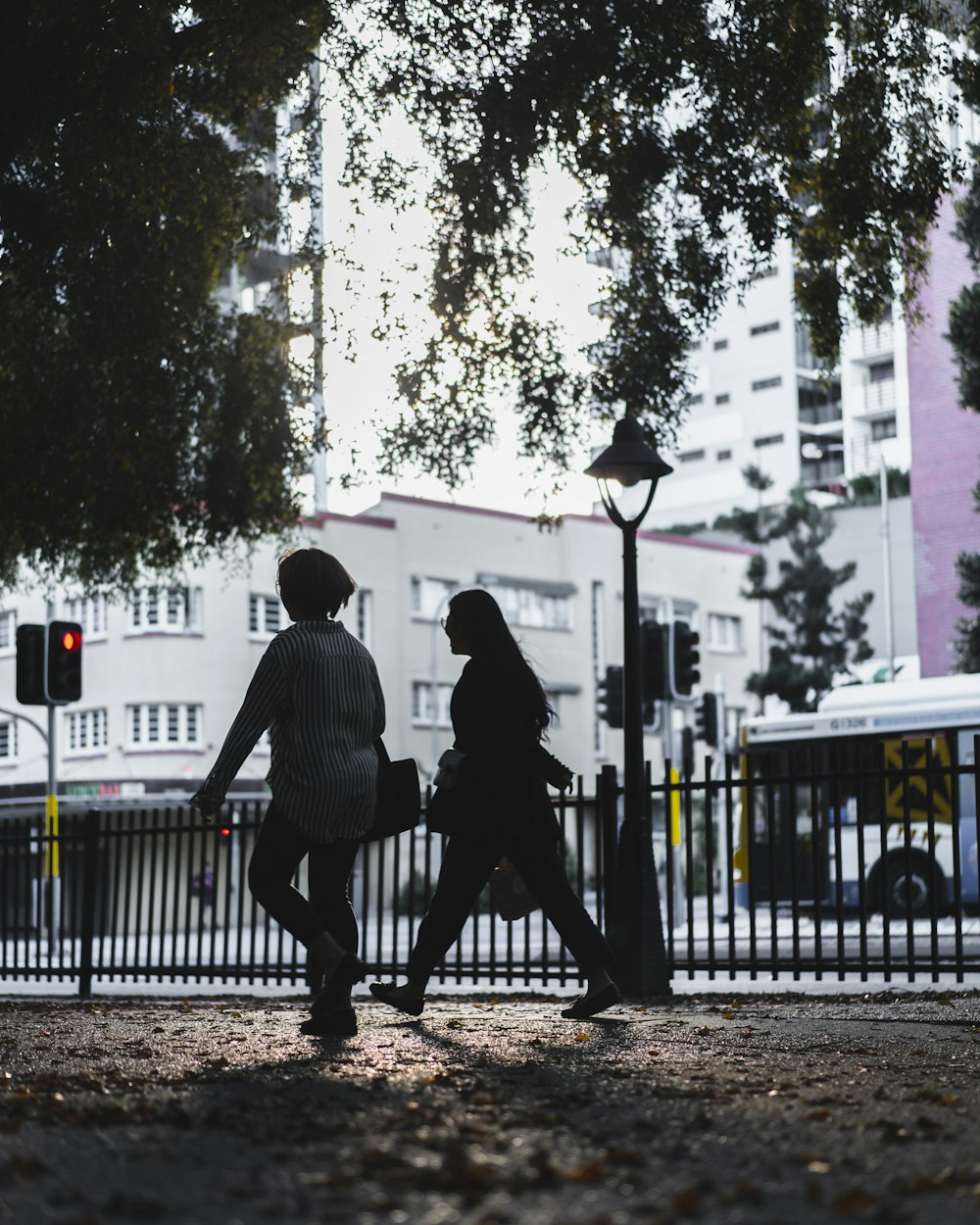 man in black jacket and black pants walking on sidewalk during daytime