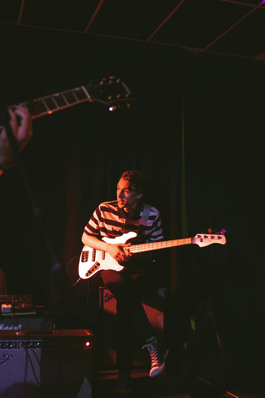 man in black and white plaid dress shirt playing electric guitar