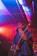 Dominic Holmes passionately playing guitar on stage under soft amber lighting.