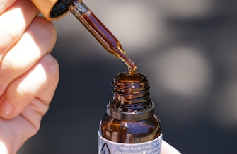 person holding brown glass bottle