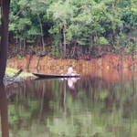 man in brown boat on lake during daytime