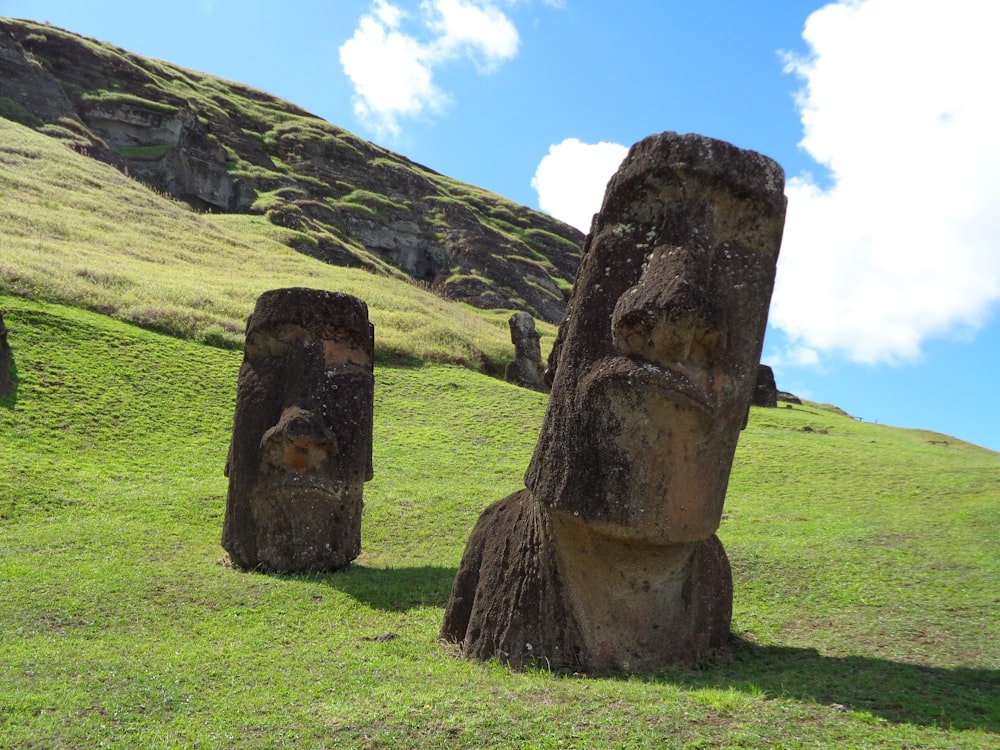 brown rock formation on green grass field during daytime