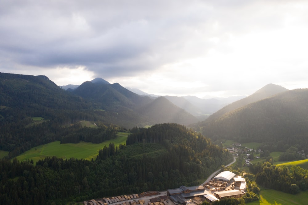 green trees and mountains under white clouds during daytime