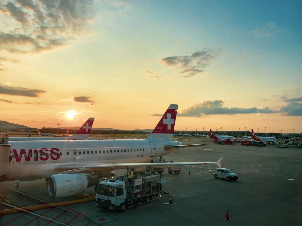 weißes und rotes Flugzeug tagsüber am Flughafen