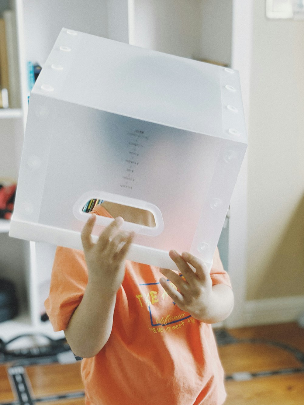 person holding white box with white paper