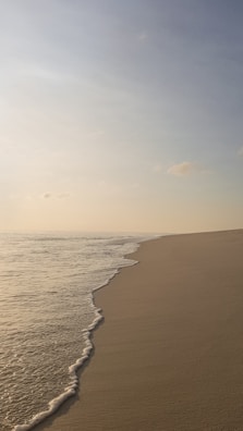 Golden sands and turquoise waves at a peaceful beach in Goa during sunrise.