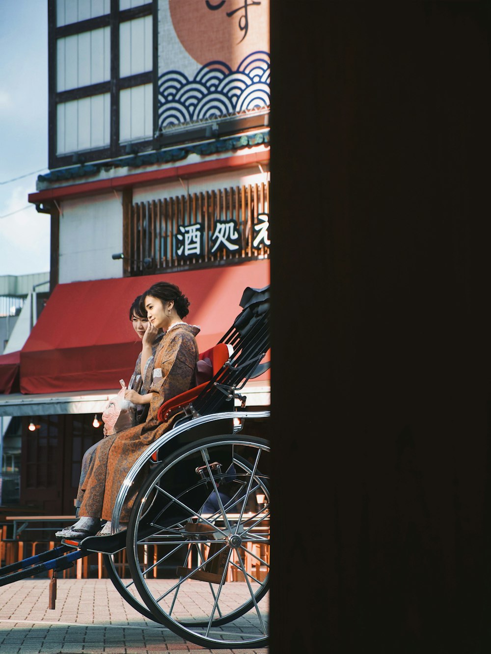 femme en robe rouge assise sur un fauteuil roulant noir