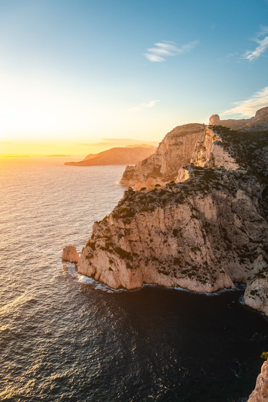 brown rock formation beside body of water during daytime in Marseille France