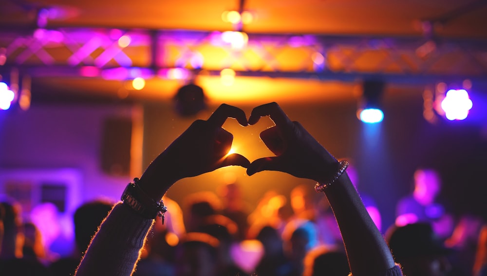 a person making a heart shape with their hands