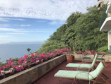View of the private terrace from the Royal Suite, featuring lush greenery and a cozy seating area.
