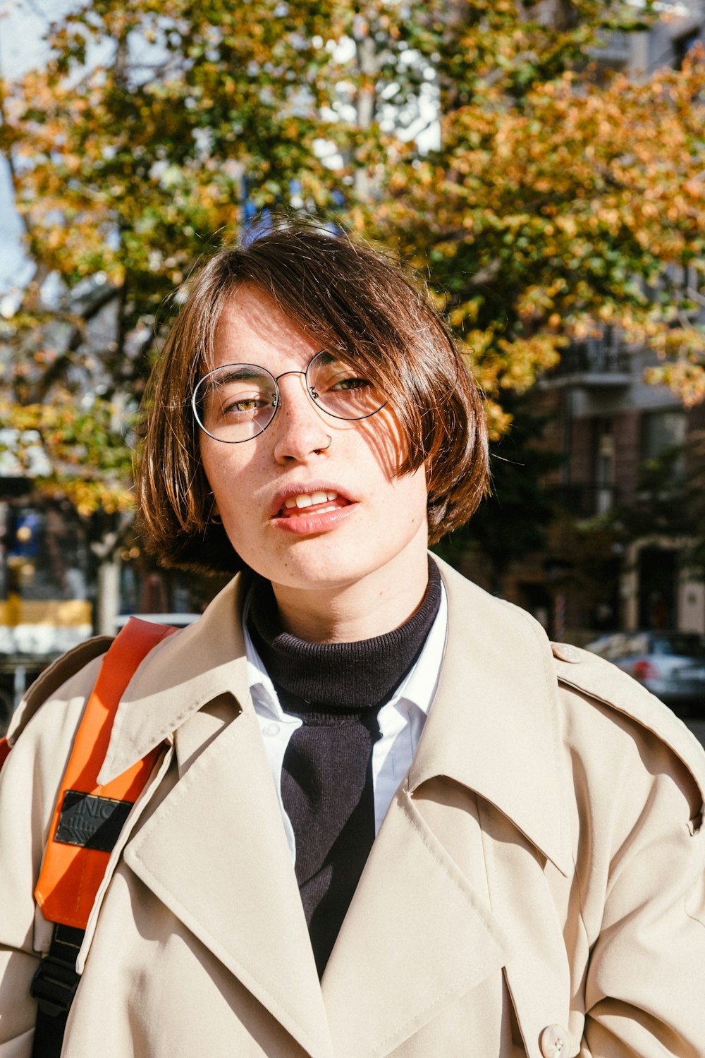 Femme en manteau marron portant des lunettes à monture noire