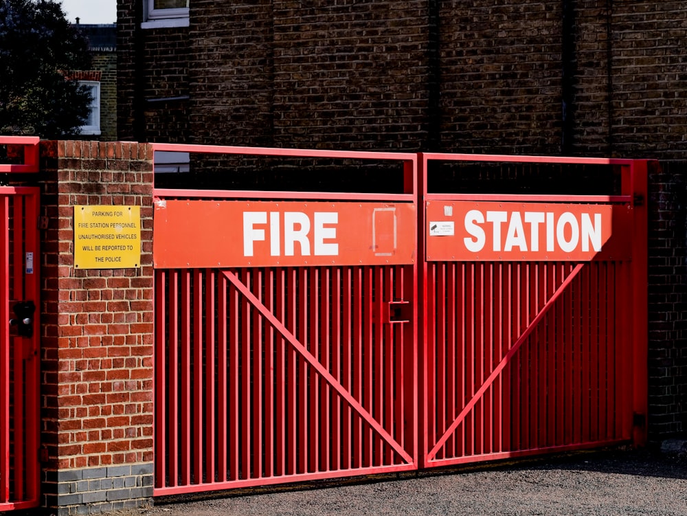 a red fire station gate with a brick building in the background