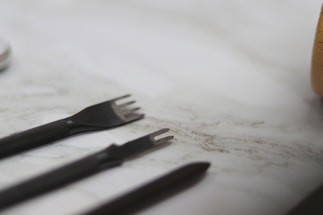 Close-up of various professional book binding tools on a workspace.
