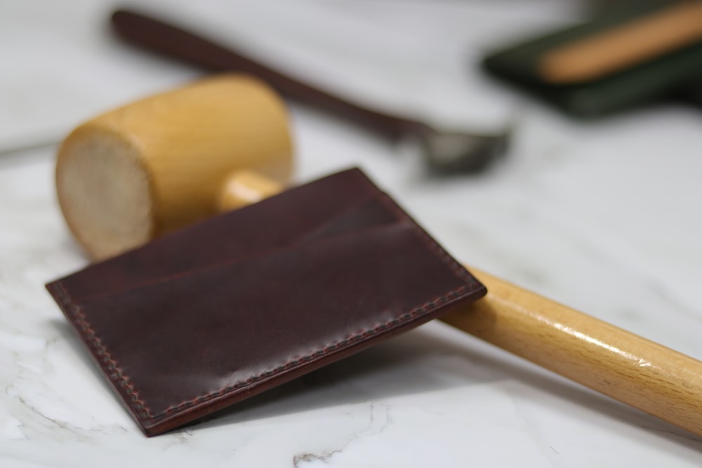 brown leather bifold wallet on white printer paper