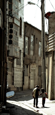 Children playing in a narrow alley, their shadows long on the whitewashed walls.