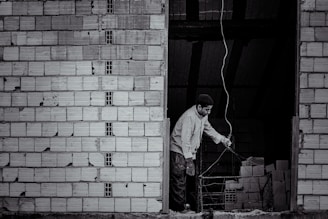 Image of a man installing electrical wiring inside a residential building.