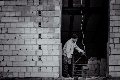 A skilled electrician installing wiring inside a modern building under construction in Douala.