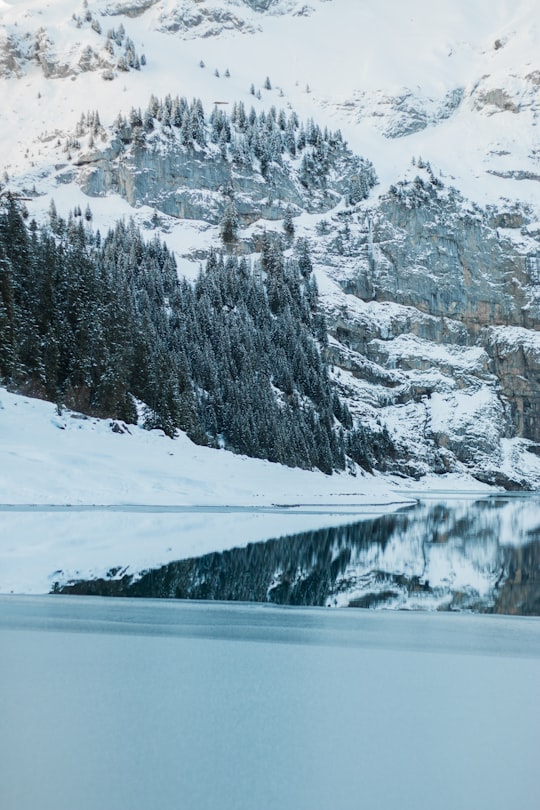 snow covered mountain near body of water during daytime in Oschinensee Switzerland