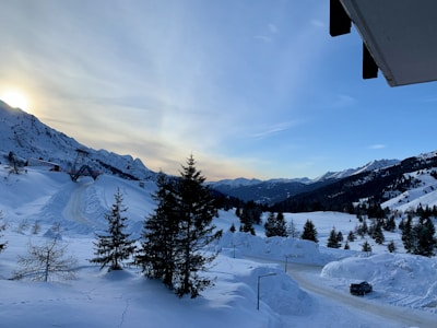 A cozy taxi parked beside the snow-capped mountains of Manali at sunrise.