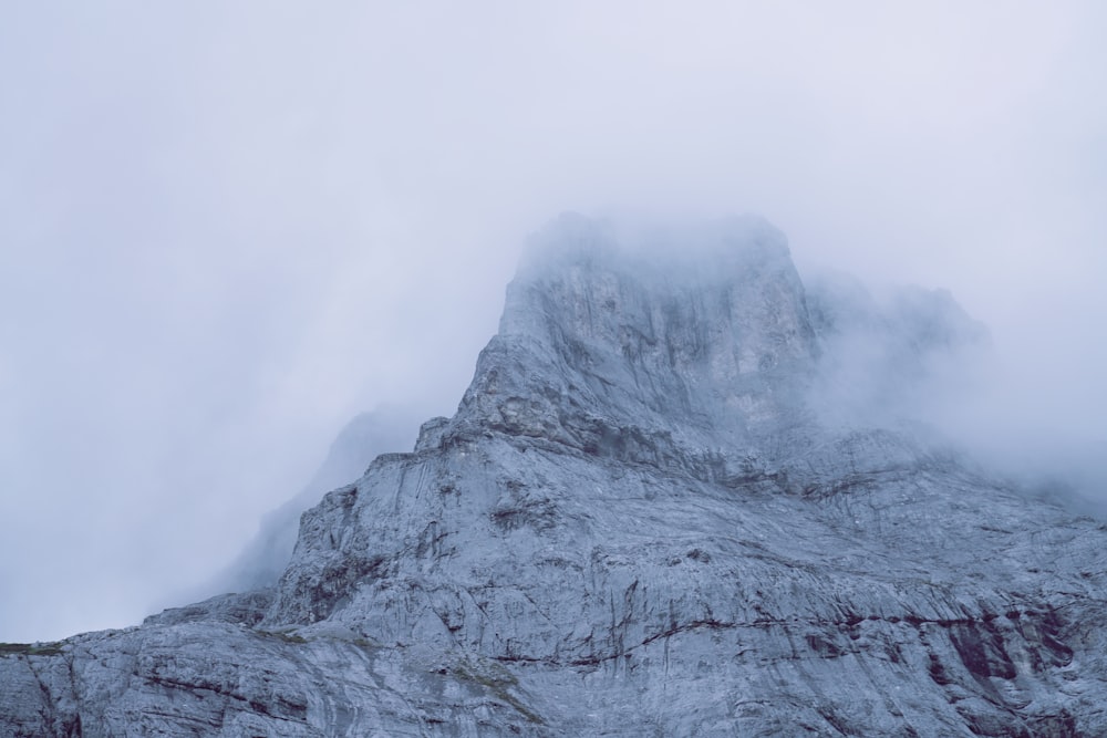 gray rocky mountain covered with white clouds