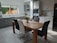 A modern kitchen featuring stylish cabinets and a dining table with chairs.