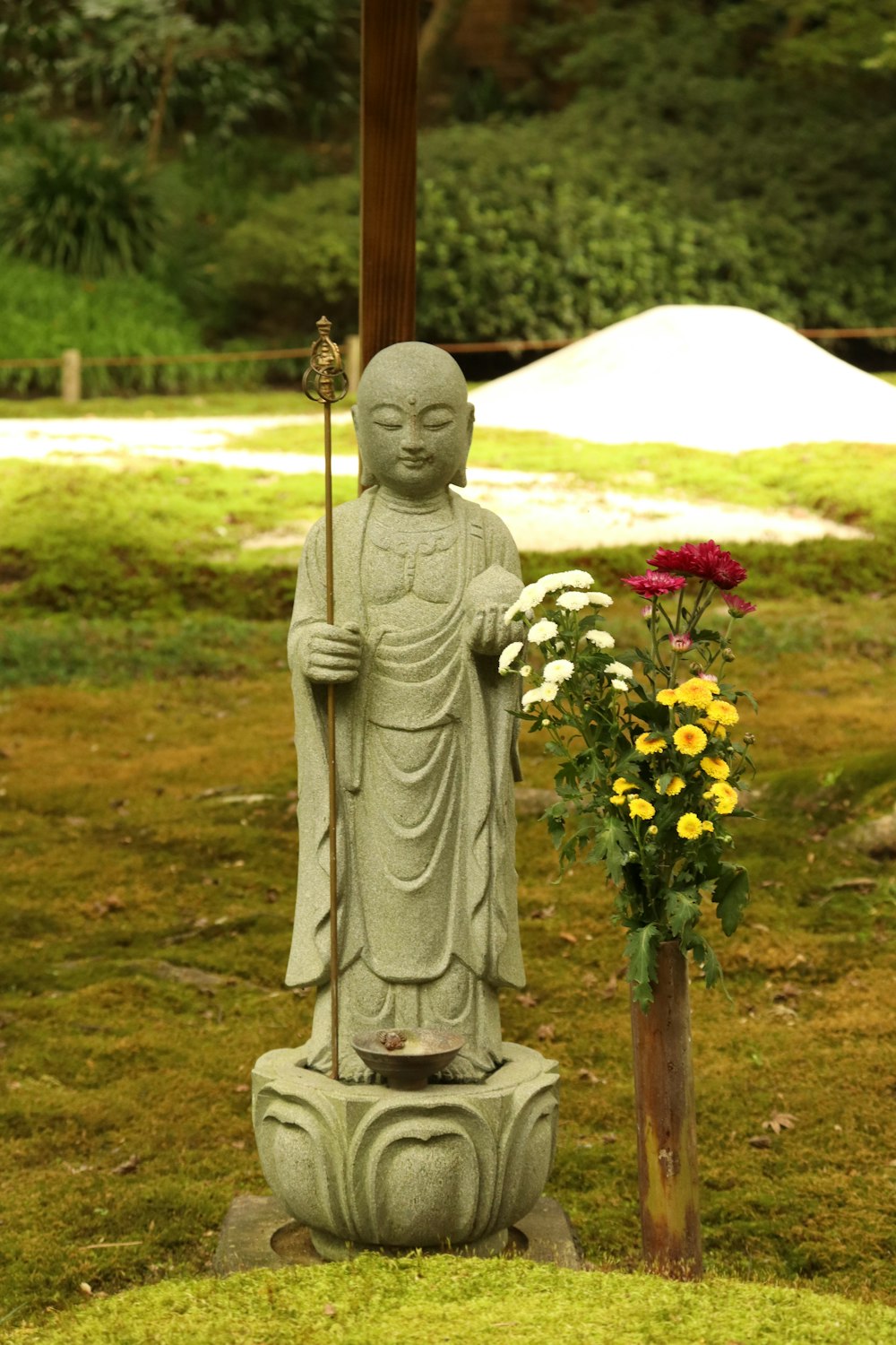 white ceramic angel figurine on green grass field