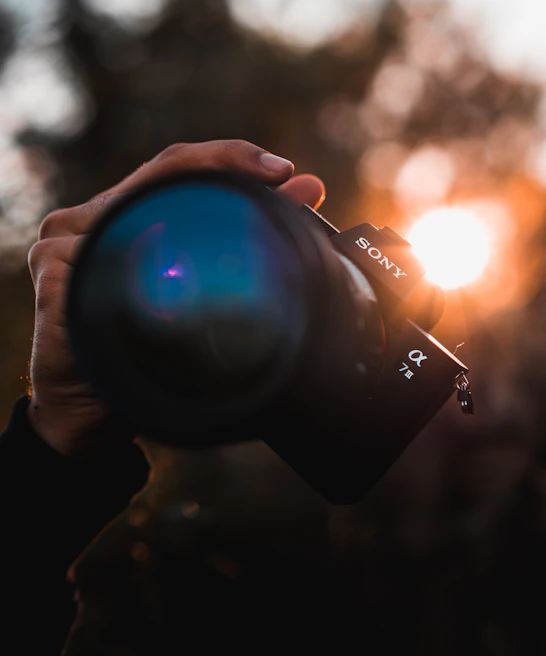Close-up of a Sony FX6 camera capturing a vibrant street scene with golden hour lighting