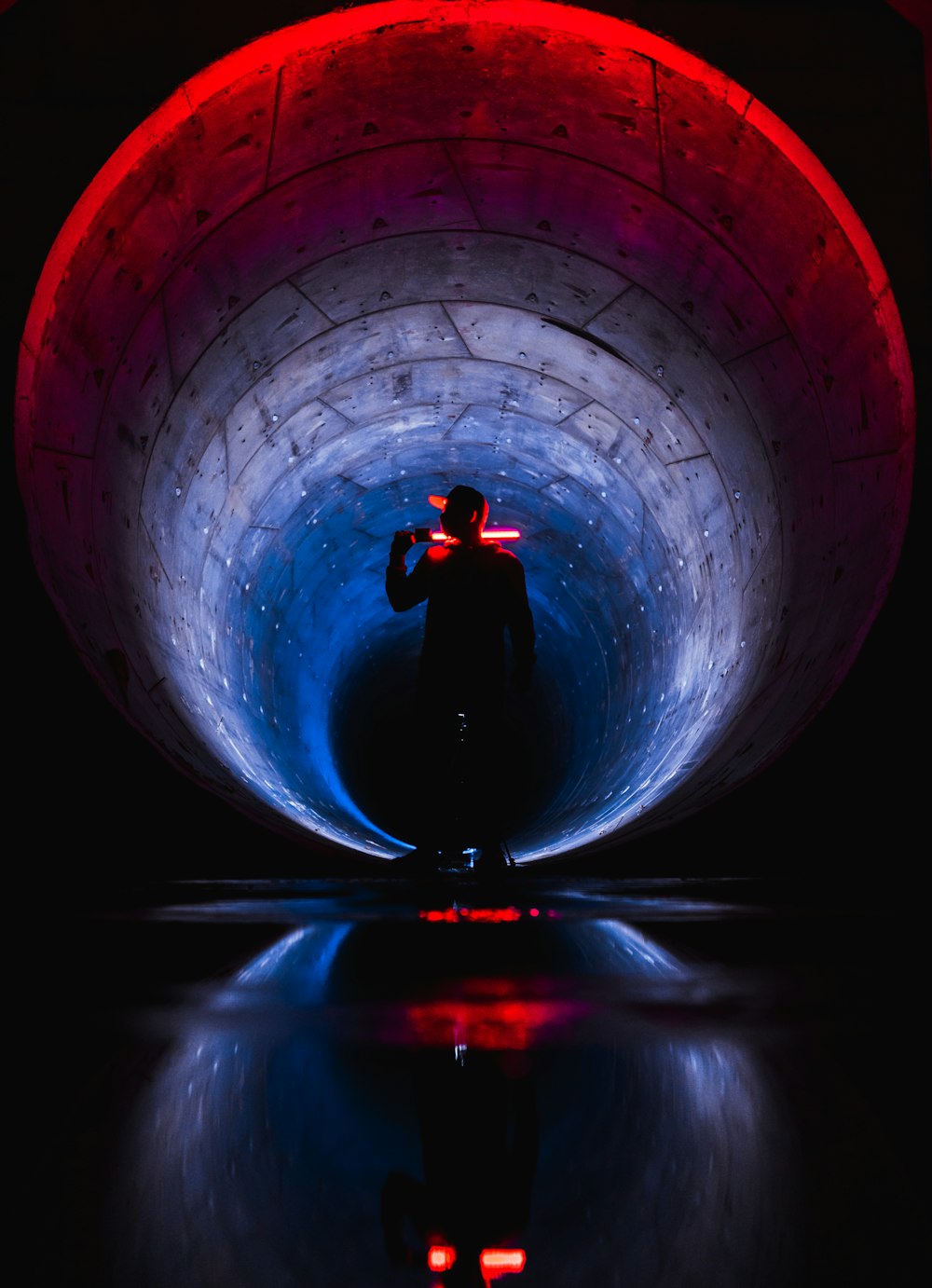 man in black jacket standing on tunnel