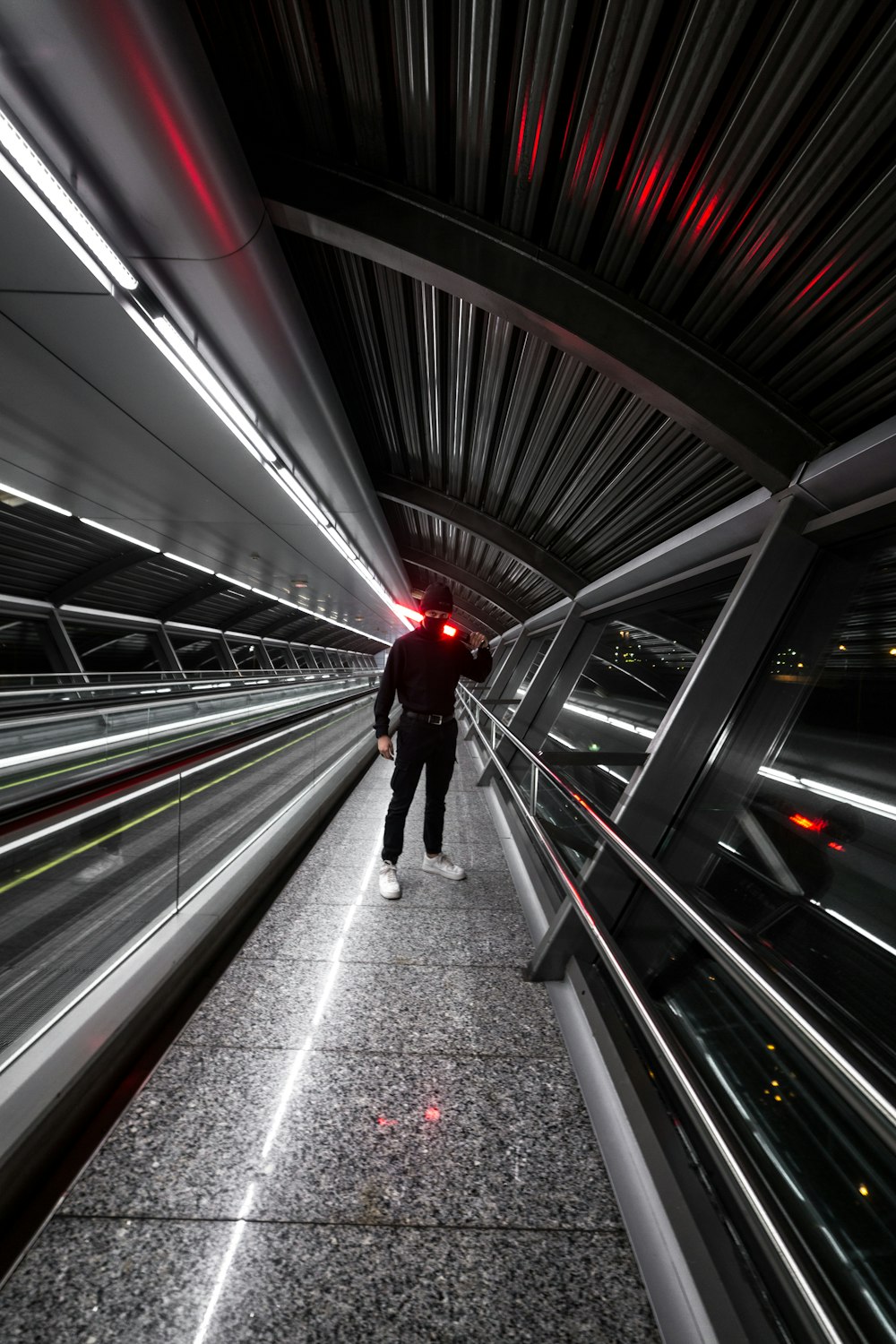 man in red jacket walking on escalator