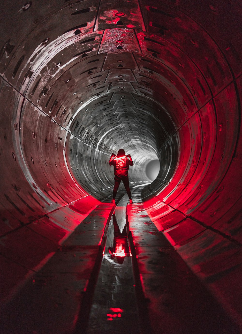 person in red shirt walking on tunnel