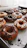 A colorful assortment of freshly made donuts with powdered sugar and glaze on a bakery tray.