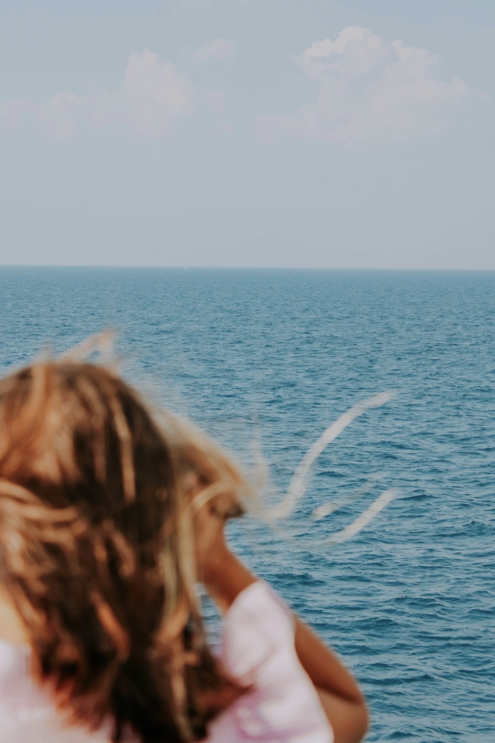 woman in blue tank top standing on blue sea during daytime