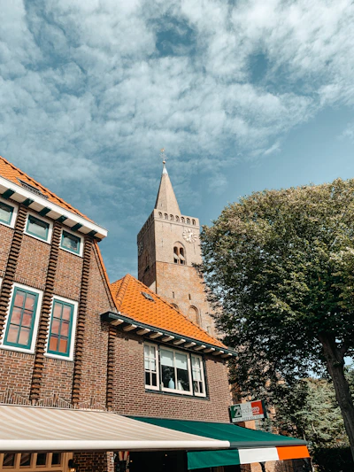 brown concrete building near green trees under blue sky during daytime