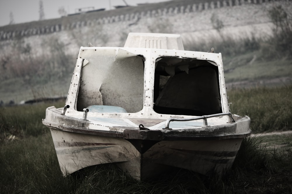 white and blue boat on green grass during daytime