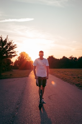 Royal electra electric scooter speeding along a coastal road with sunset.