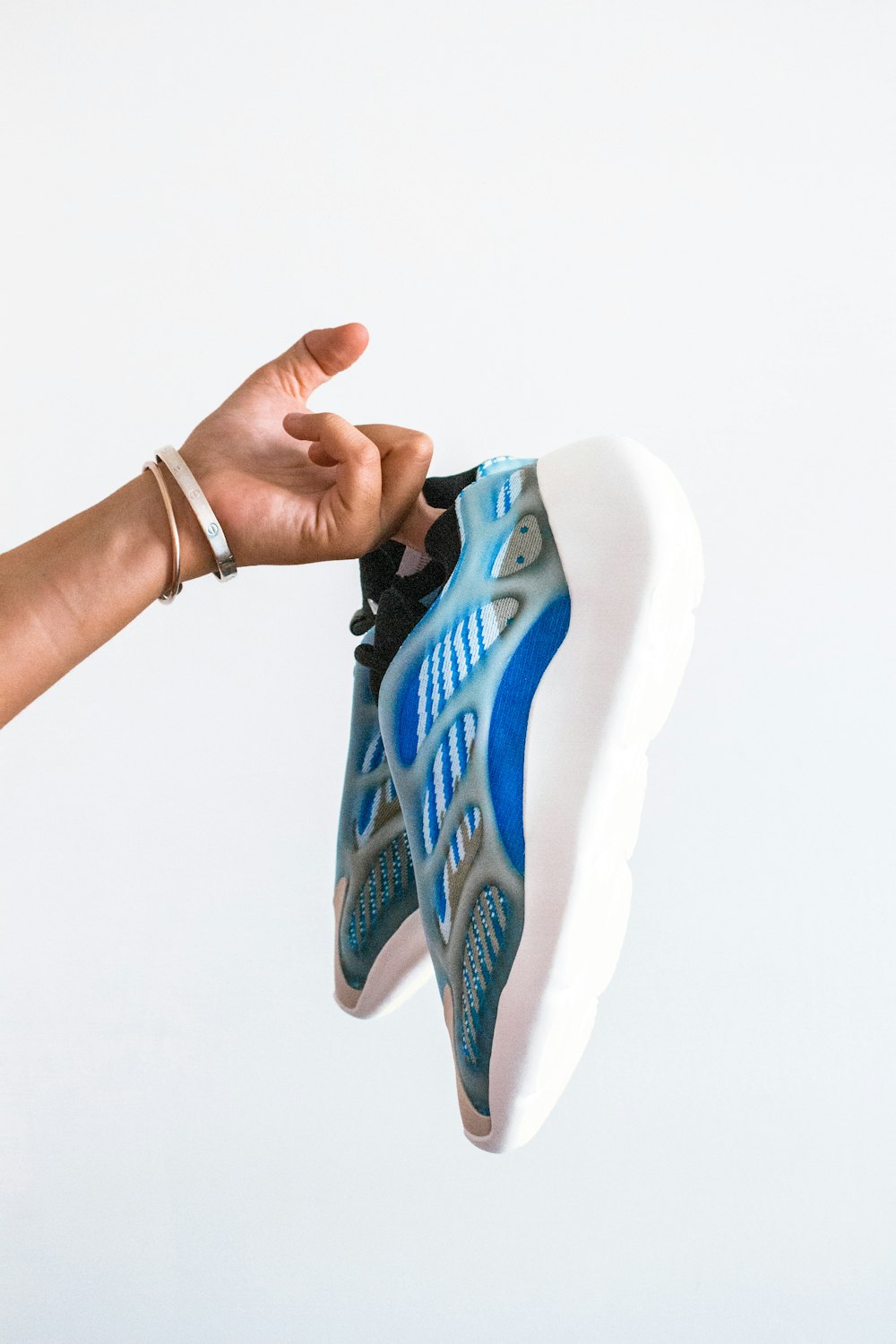 person holding white and blue nike shoe