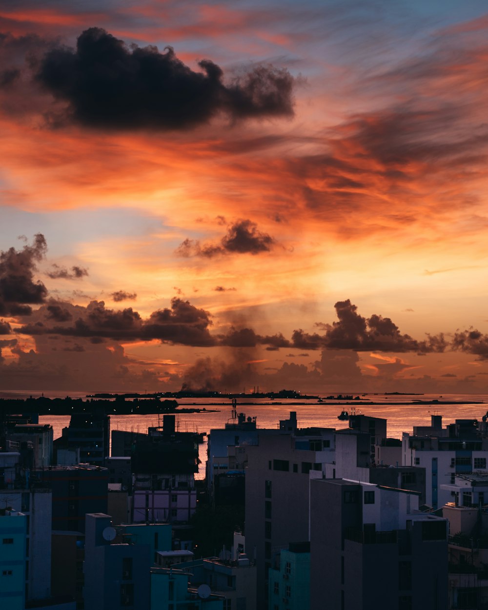 Weiße und schwarze Betongebäude unter bewölktem Himmel bei Sonnenuntergang