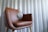 silver round pendant on brown wooden chair