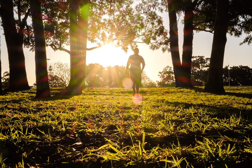 person walking on green grass field during daytime