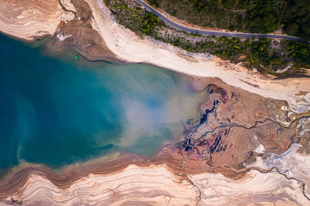 brown rocky mountain beside blue body of water during daytime