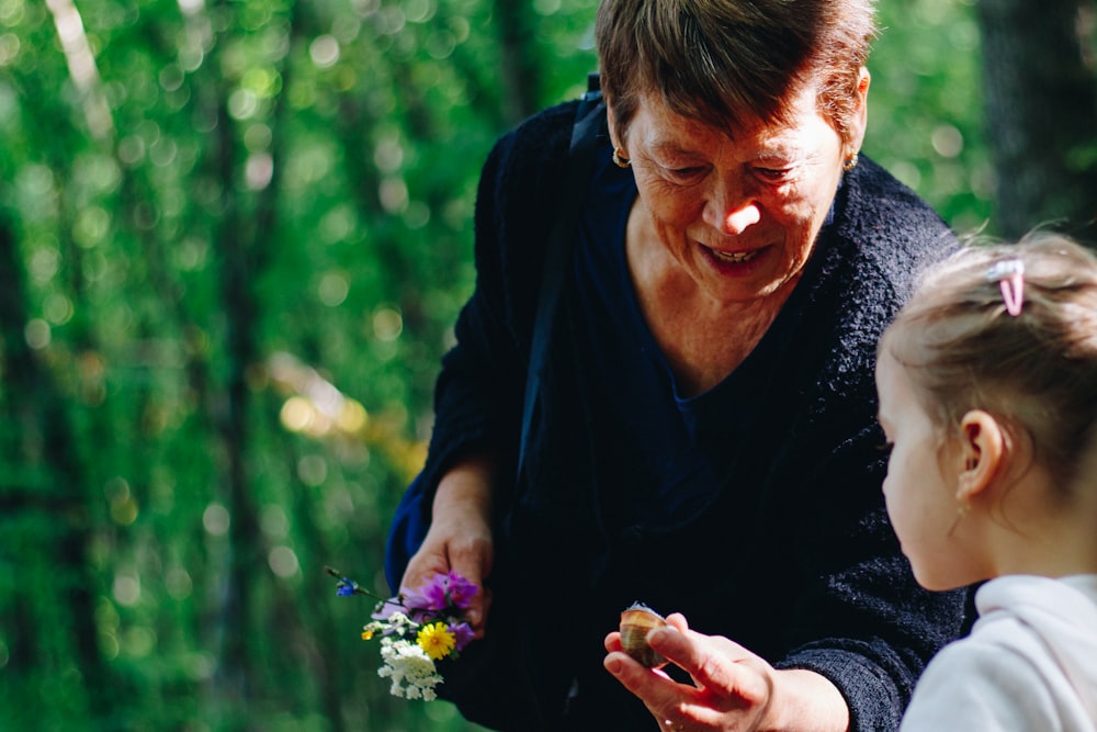 Frau in schwarzem Langarmhemd mit lila Blume