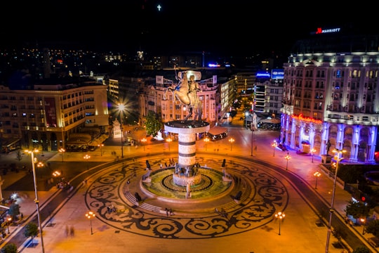 white and brown fountain in the city during night time in Skopje North Macedonia