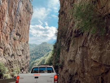 A rugged pickup truck driving through a scenic mountain road.